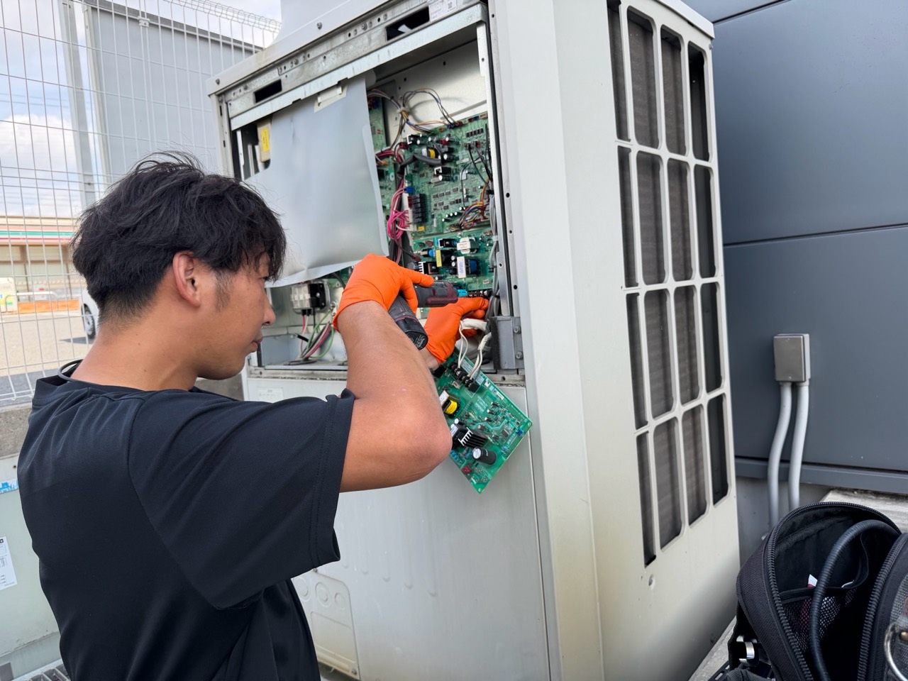 業務用室外機の制御基板まわりで作業する技術者
